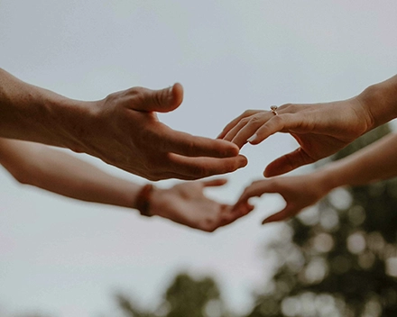 Photographie de deux jeunes mariés qui se tendent les mains.